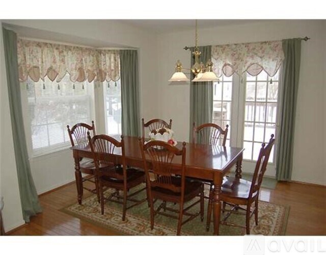 A dining room with a table and chairs.
