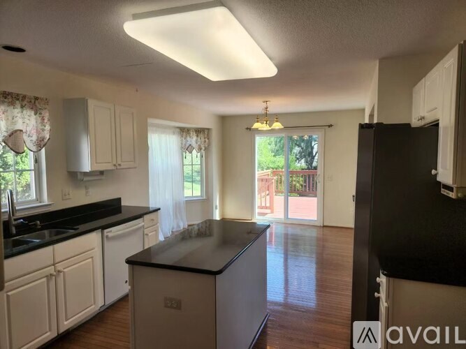 A kitchen with white cabinets and a black countertop.
