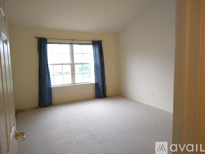 A room with a window and blue curtains.
