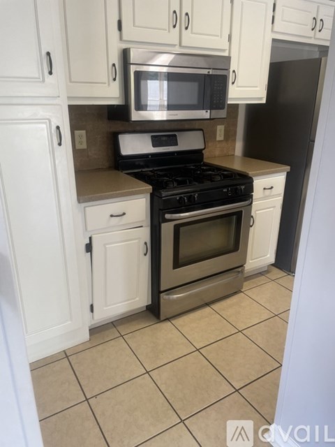 A kitchen with white cabinets and a black stove top oven.