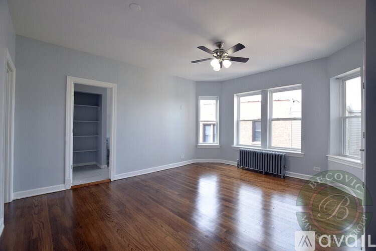A room with a ceiling fan and wooden floors.