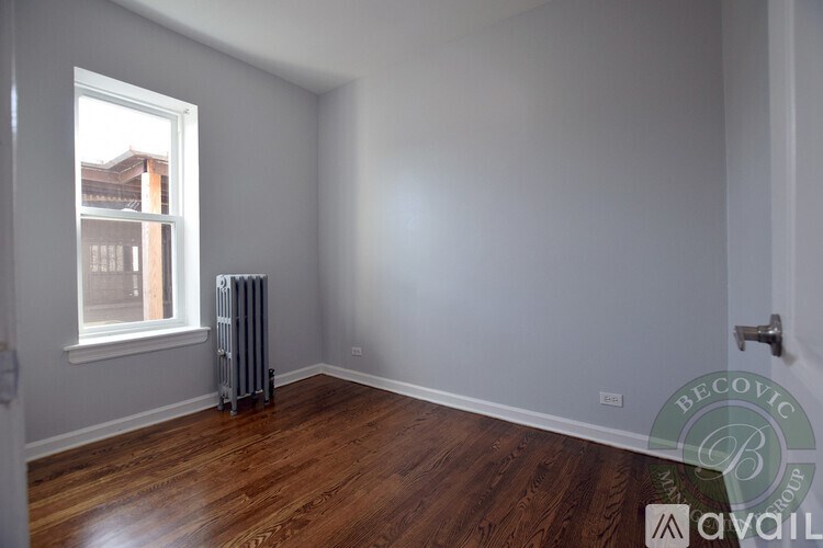 A room with a window and a radiator on the floor.