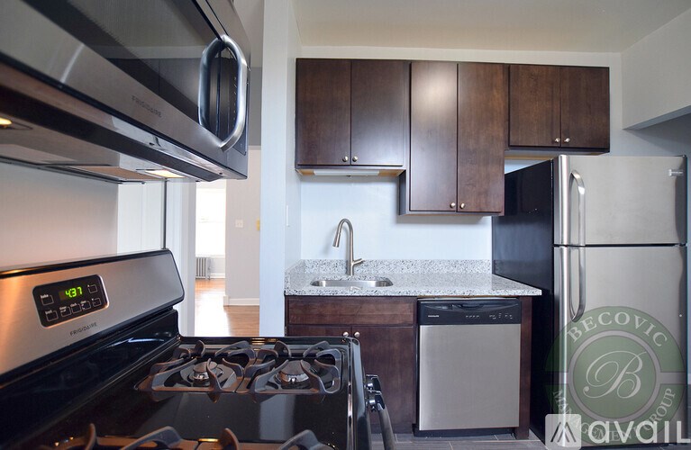 A modern kitchen with a stove top oven and a refrigerator.
