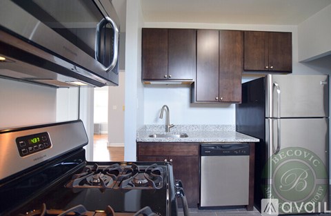 A modern kitchen with a stove top oven and a refrigerator.