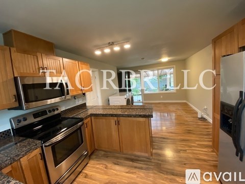 A kitchen with wooden cabinets and a granite countertop.