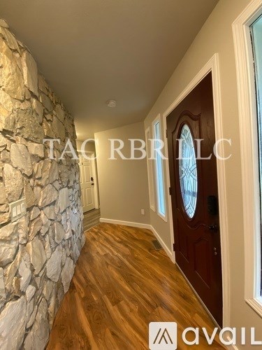 A hallway with a stone wall and wooden flooring.