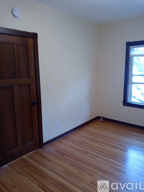 A room with a wooden floor and a brown door.