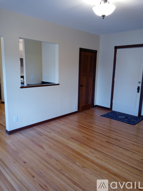 A room with wooden floors and a mirror on the wall.