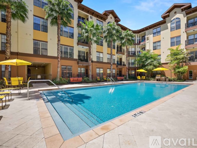 A large swimming pool in front of a multi-story apartment building.