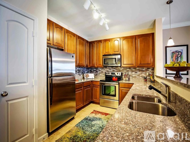 A kitchen with wooden cabinets and a stainless steel refrigerator.