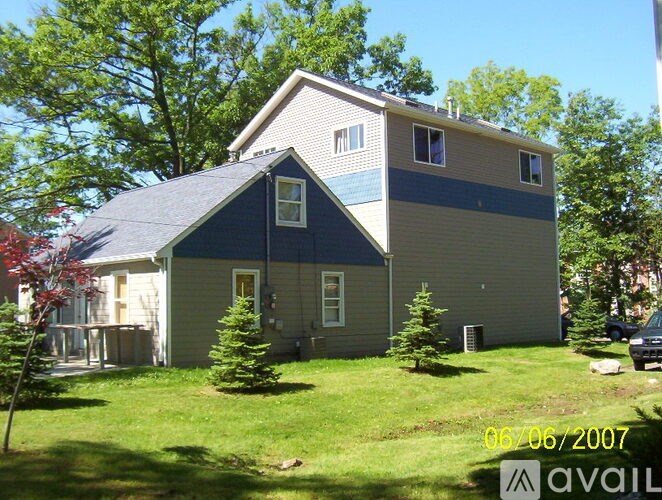A house with a blue roof and a car parked in front.
