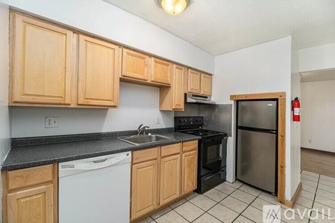 A kitchen with wooden cabinets and black countertops.