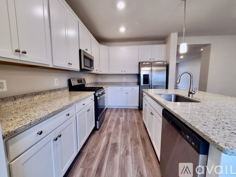 A kitchen with white cabinets and a granite countertop.