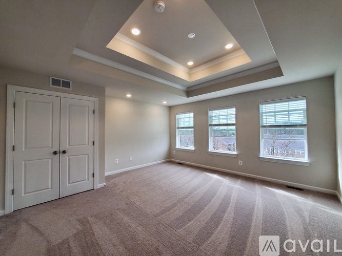 A spacious room with a carpeted floor and a large window.