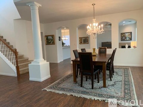 A dining room with a wooden table and chairs.