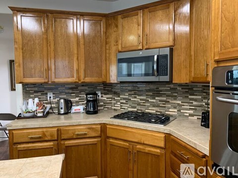 A kitchen with wooden cabinets and a stone backsplash.