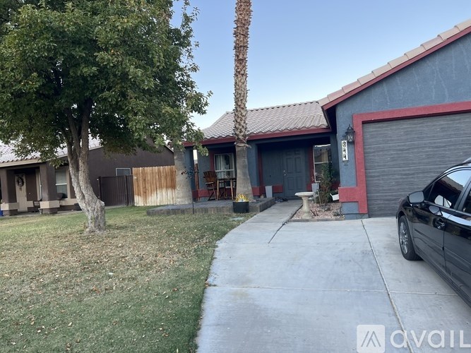 A black car is parked in front of a red garage.