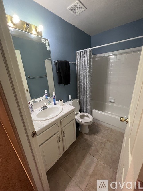 A bathroom with blue walls and a white toilet.