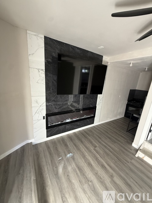 A bedroom with a white bed and carpeted floor.