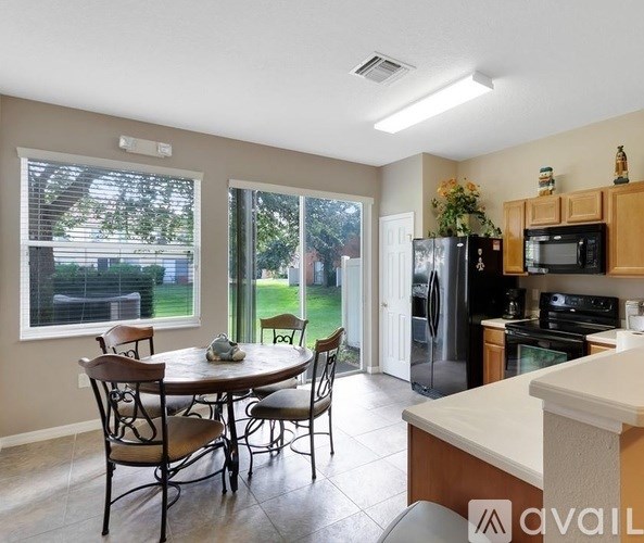 A kitchen with a table and chairs in front of a window.
