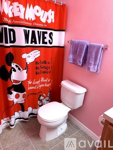 A bathroom with a Mickey Mouse shower curtain.