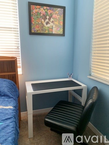 A room with a bed, desk, and chair.