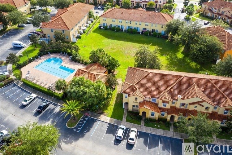 A bird's eye view of a residential area with a swimming pool and a parking lot.