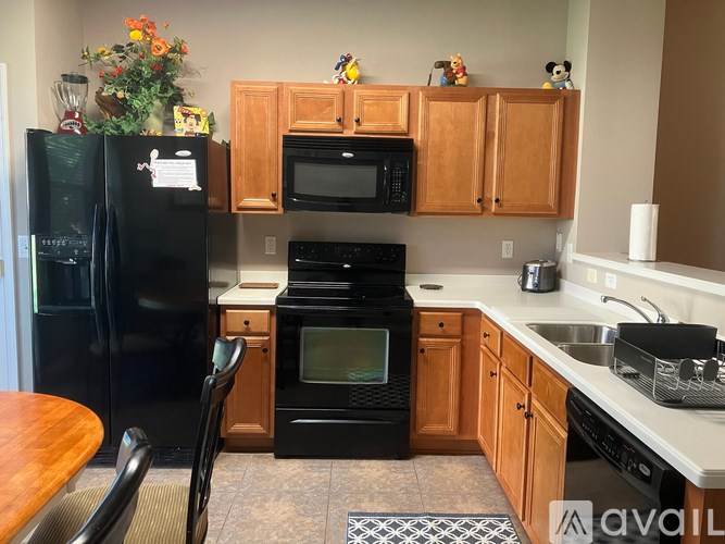 A kitchen with black appliances and wooden cabinets.