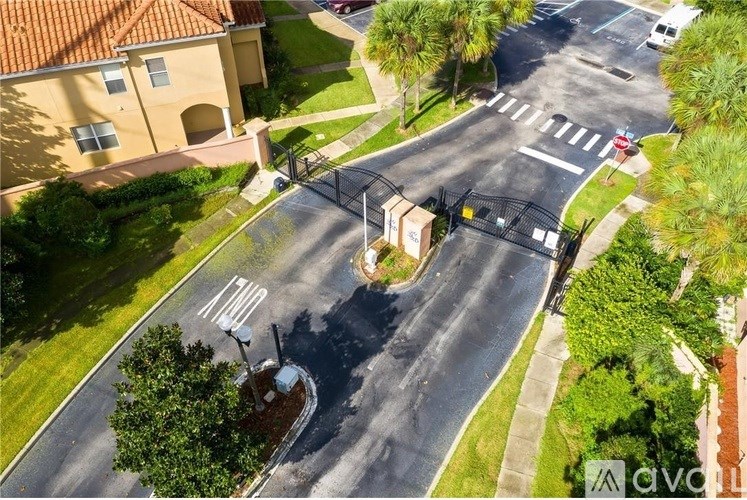 A street view with a house and a tree in the foreground.