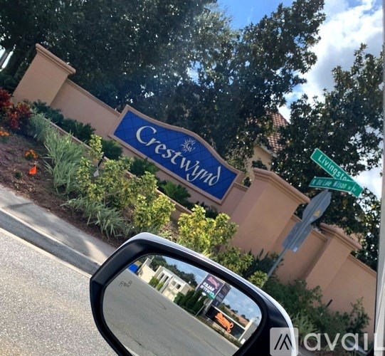 A car is parked in front of a Crestwinds sign.