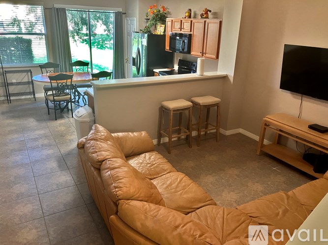 A living room with a tan couch and a television.