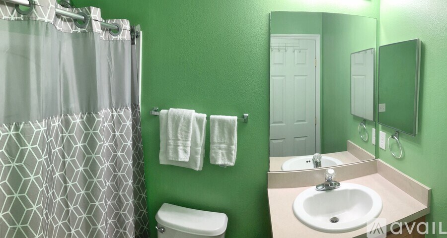 A bathroom with green walls and a white toilet.