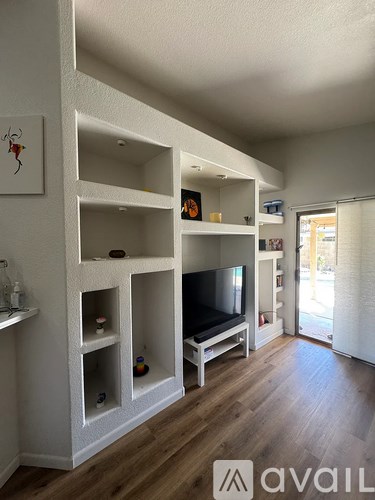 A living room with a television and built in shelves.