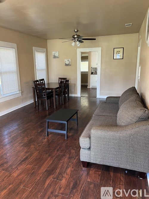 A living room with a couch, chairs, and a dining table.