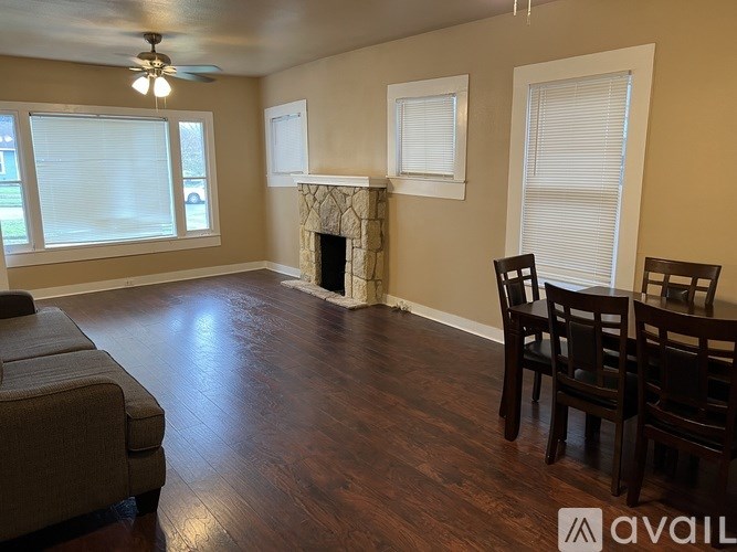 A living room with a fireplace and two chairs.