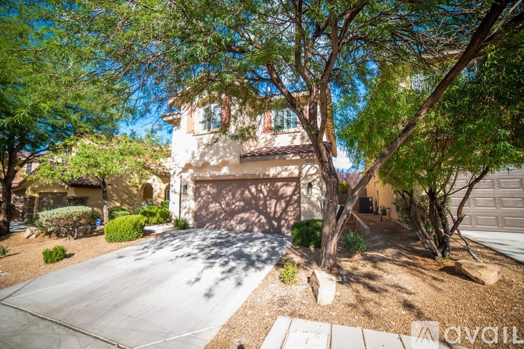 A house with a driveway and trees in front.