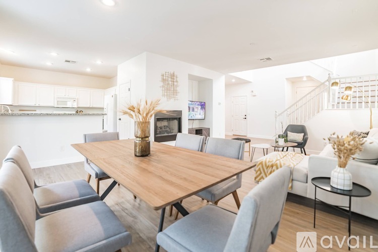 A modern dining room with a wooden table and grey chairs.