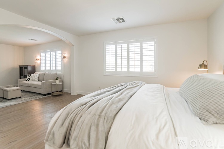 A bedroom with a large bed and a couch.