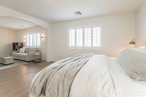 A bedroom with a large bed and a couch.