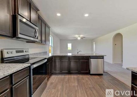 A kitchen with dark brown cabinets and a white countertop.