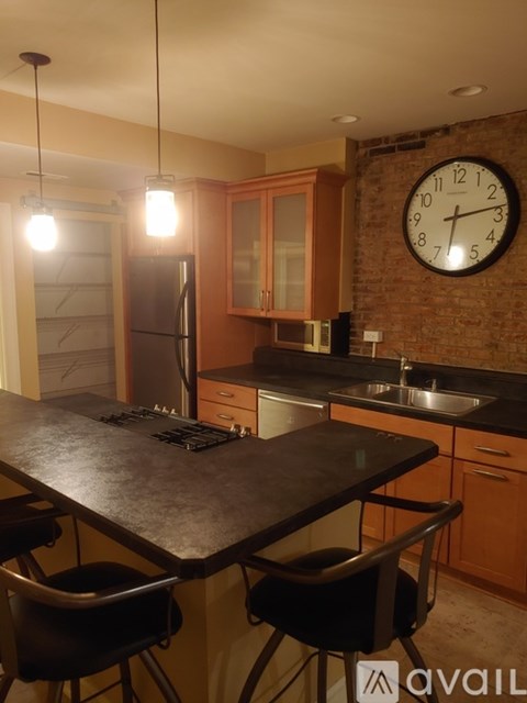 A kitchen with a black table and a brick wall clock.