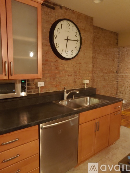A kitchen with a brick wall and a clock on it.