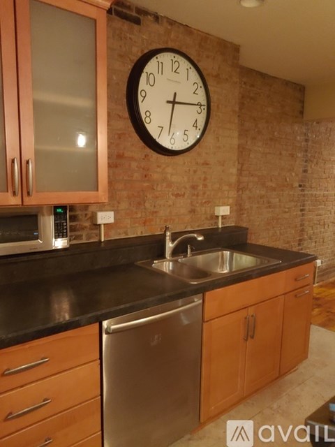 A kitchen with a brick wall and a clock on it.