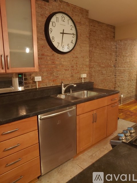 A kitchen with a brick wall and a clock on it.