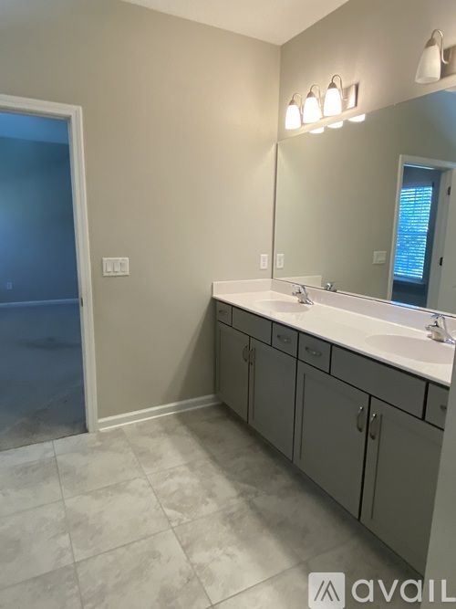 A bathroom with a sink, mirror, and cabinets.