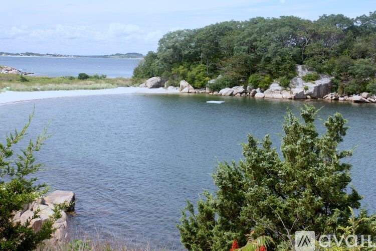 A serene lake surrounded by lush greenery and rocks.