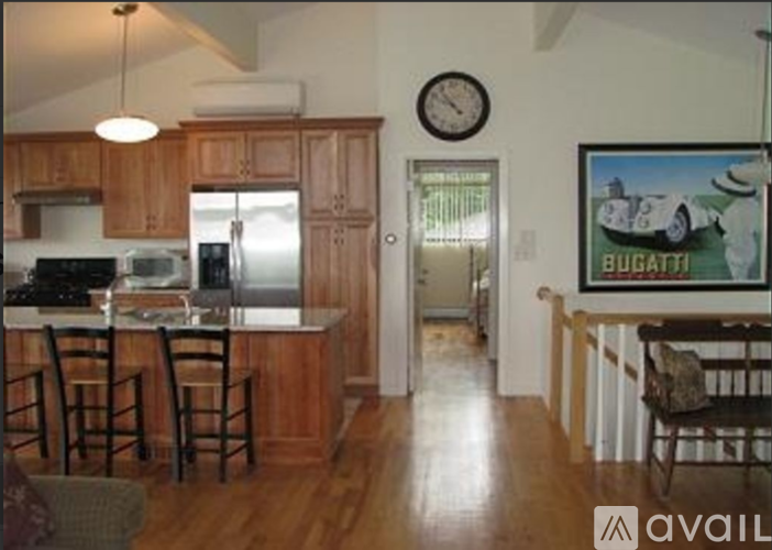 A kitchen with wooden cabinets and a painting of a Bugatti on the wall.