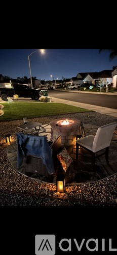 A backyard with a fire pit and chairs.