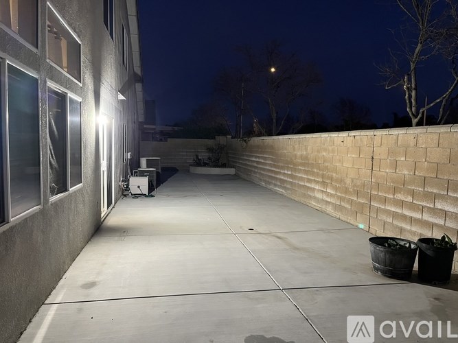 A dark alley with a wall on one side and a trash bin on the other.