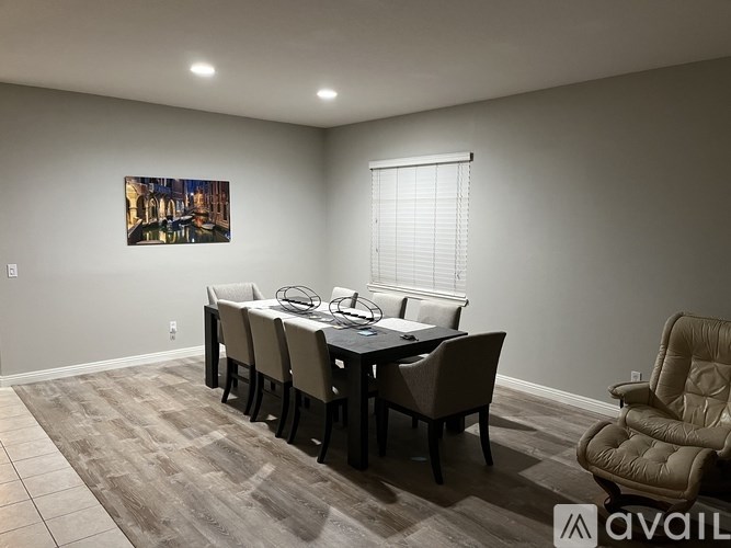 A dining room with a large table and chairs.
